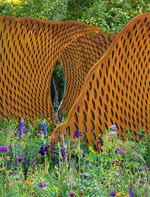 A series of bronze and oxidized steel screens tell the story of mankind