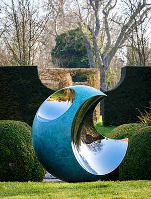 Bite copper sculpture in a traditional English garden
