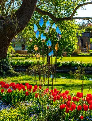 Quiver flower sculpture emerging from a clump of bright red tulips