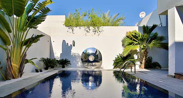 Torus sculpture reflected in an outdoor swimming pool