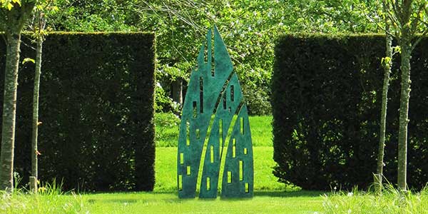 Eveque sculpture as a garden feature in the break between two hedges