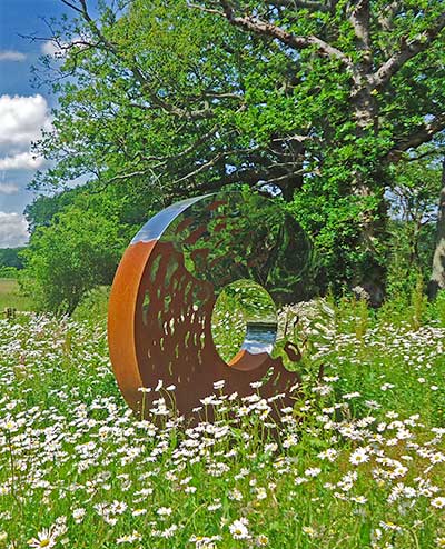 Exterior bronze art surrounded by flowers