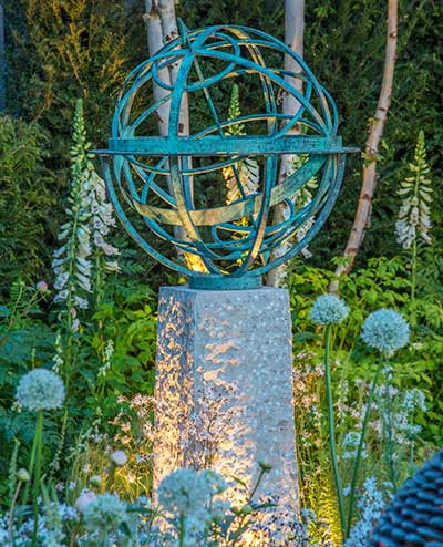 Bronze sundial in classic garden setting